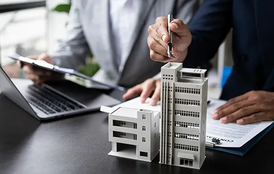 Business professional holding a miniature building model, representing commercial fix and flip loan services in Tampa, FL.