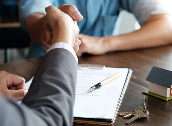 A business handshake over a contract and clipboard, symbolizing industrial fix and flip loan agreements in Memphis TN.